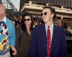 American actress Courteney Cox and American actor Michael Keaton, both wearing sunglasses, attend the Hollywood premiere of 'Batman Returns', at the Mann Chinese Theater in the Hollywood neighbourhood of Los Angeles, California, 16th June 1992. (Photo by Vinnie Zuffante/Getty Images)