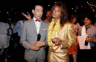 Comedian & actor Paul Reubens (1952 - 2023) (left), as his character Pee-Wee Herman, and singer David Lee Roth pose together at the premiere of the movie